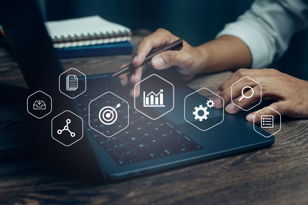 Several Project management icons that overlay a picture of a man working on a notebook.